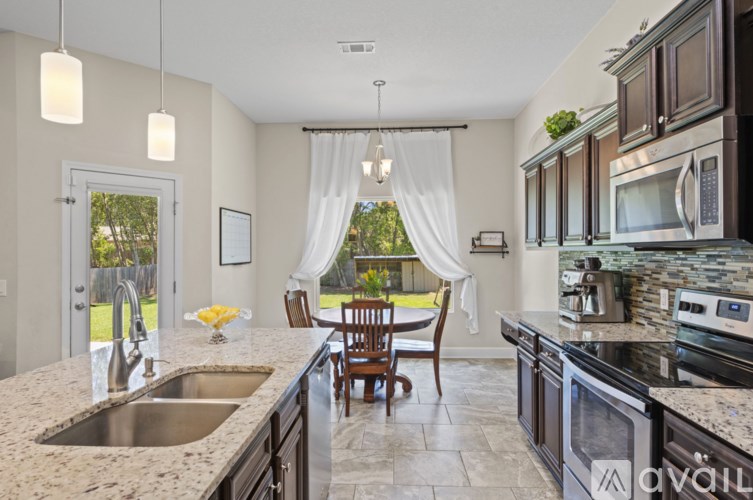 A kitchen with granite countertops and a dining table set for two.