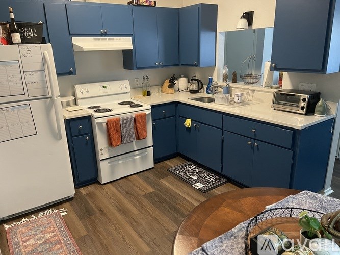 A kitchen with a white fridge and a white stove.