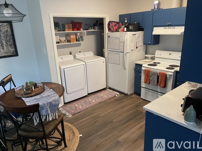 A kitchen with a table and chairs in front of it.