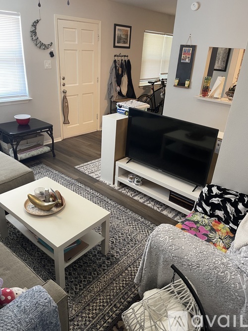 A living room with a black TV and a white coffee table.