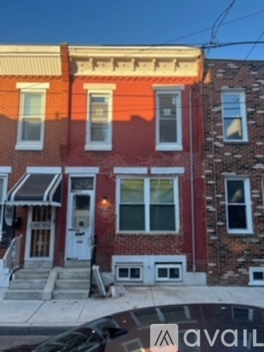 A red brick house with a white door and windows.