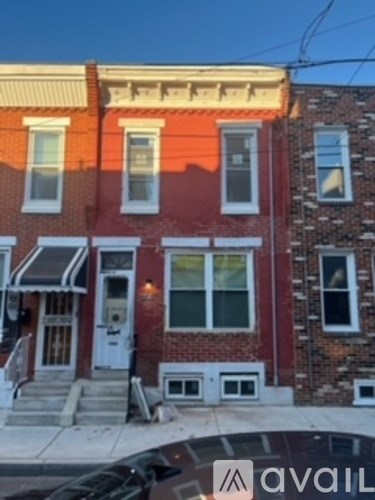A red brick house with a white door and windows.