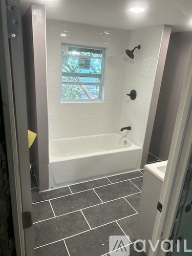 A bathroom with a tub and a window.
