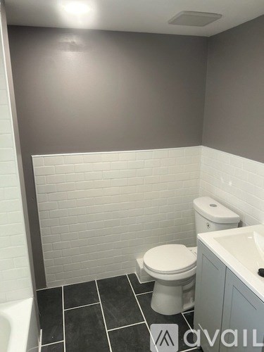 A bathroom with a toilet, sink, and a bathtub.