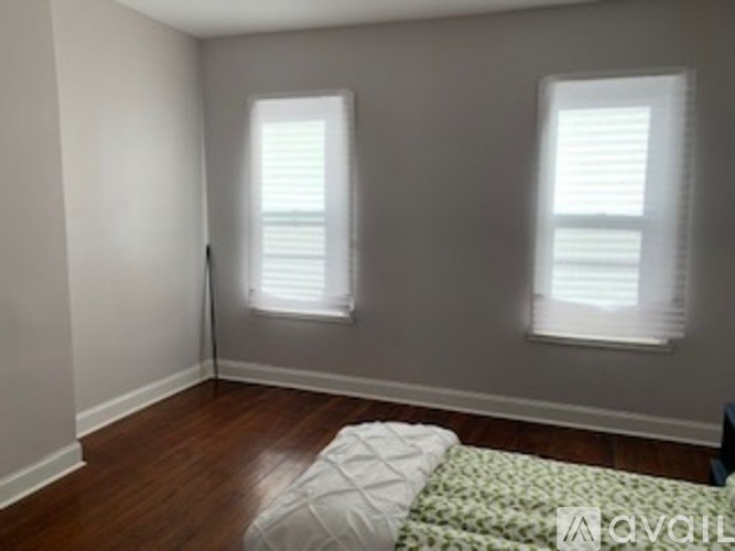 A room with a bed and two windows.