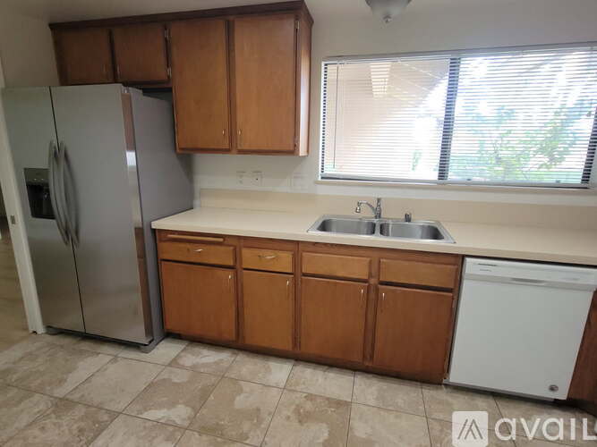 A kitchen with wooden cabinets and a white dishwasher.