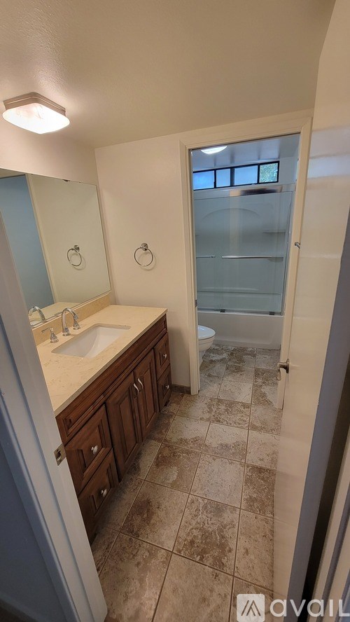 A bathroom with a sink, toilet, and shower.