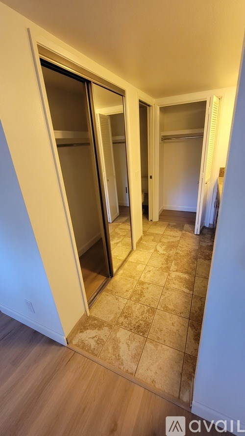 A hallway with a tiled floor and a glass door.