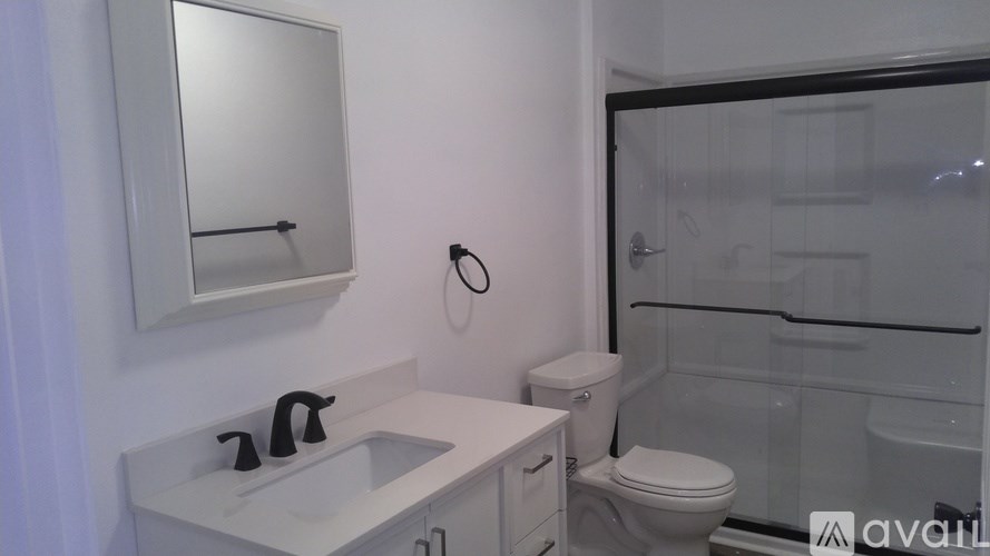 A bathroom with a sink, toilet, and shower.