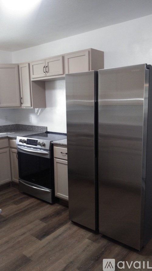A kitchen with a stainless steel refrigerator and a stove.