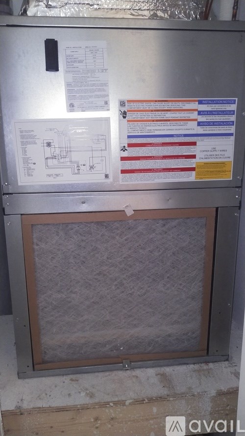 A metal box with a grey mesh front and several papers attached to it.