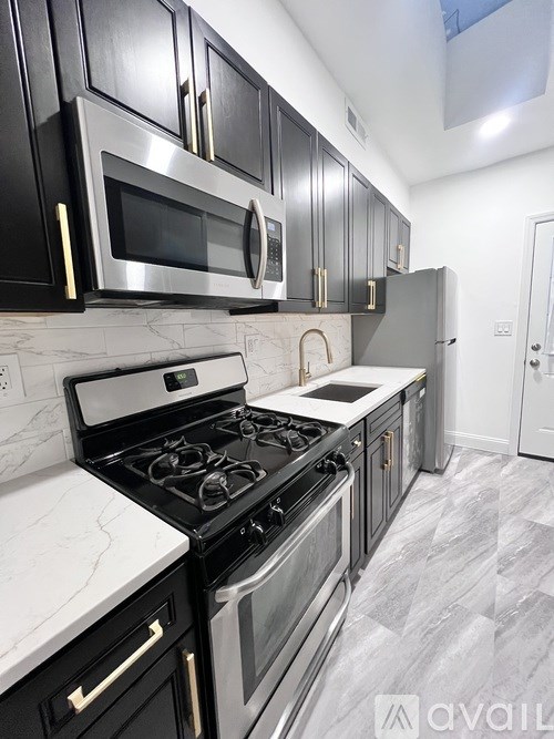 A kitchen with black cabinets and a stove top oven.