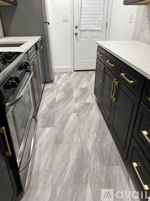A kitchen with black cabinets and a white door.