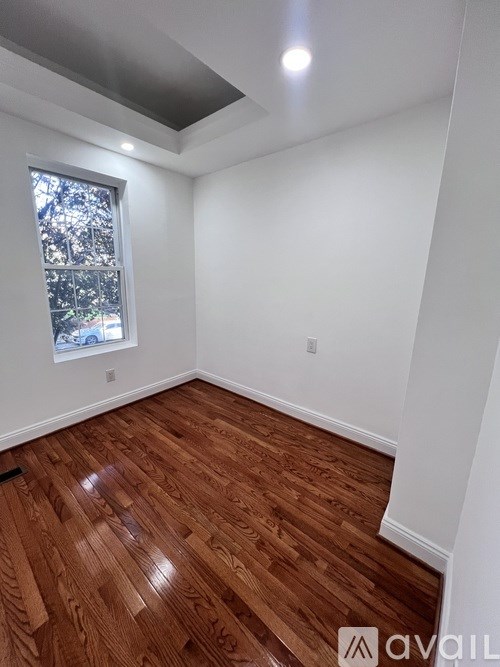 A room with wooden flooring and a window.