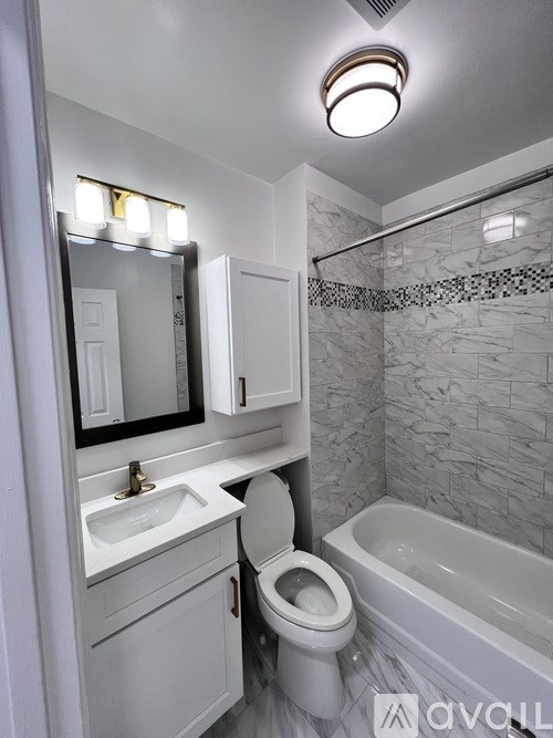 A white bathroom with a sink, toilet, and bathtub.