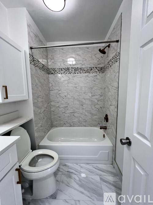A white bathroom with a toilet, sink, and bathtub.
