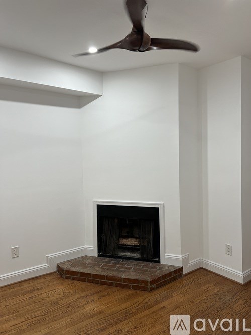 A room with a fireplace and a ceiling fan.