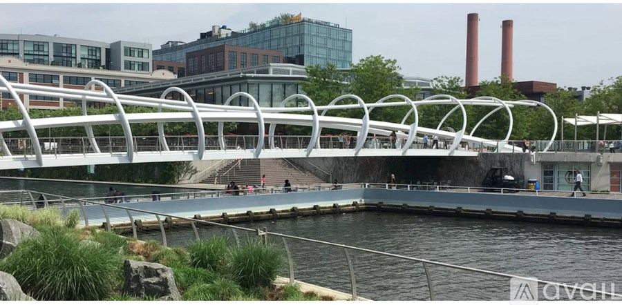A white bridge over a body of water with a building in the background.