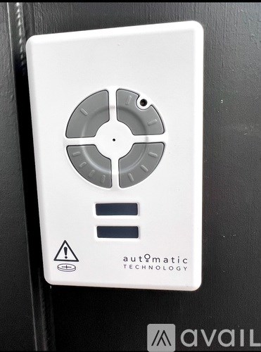 A white electrical outlet with a warning label and the logo of Automatic Technology.