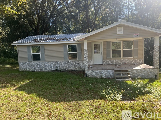 A small house with a metal roof and a porch.