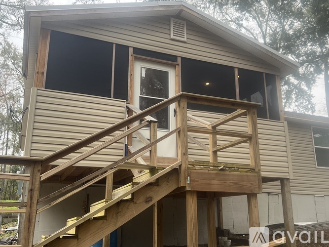 A house under construction with a wooden staircase leading to the second floor.