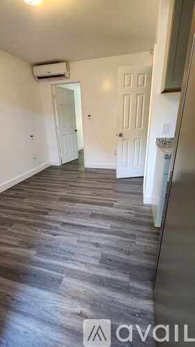 A room with a wooden floor and a white door.