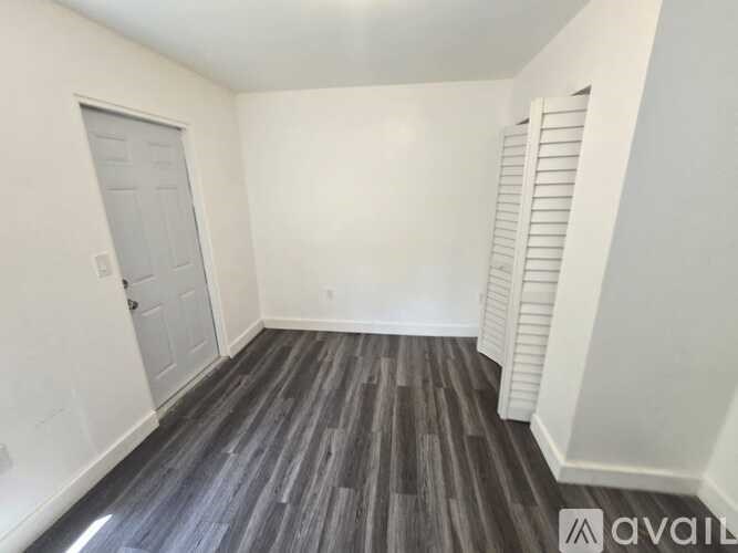 A room with a wooden floor and white walls.