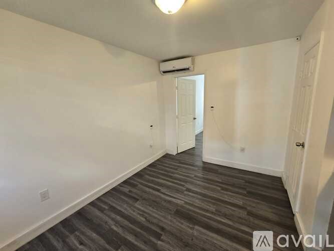 A room with a wooden floor and white walls.