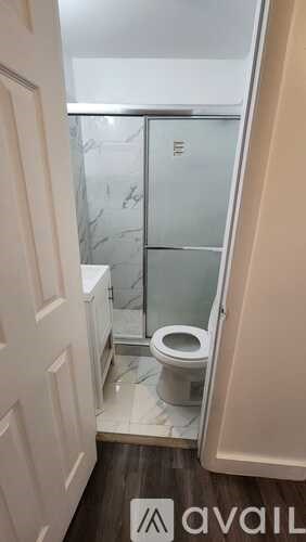 A bathroom with a toilet and a glass shower door.