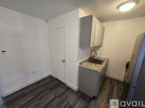A small kitchen area with a sink and cabinets.