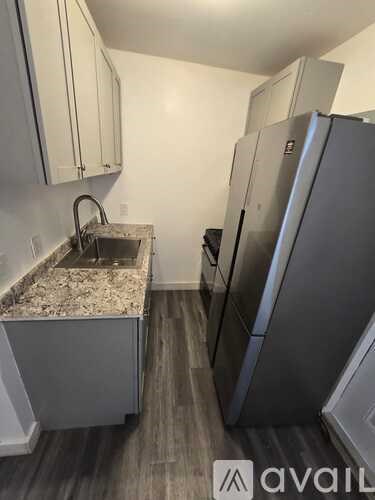 A kitchen with a granite countertop and a refrigerator.