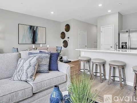 A living room with a grey couch and a bar area.