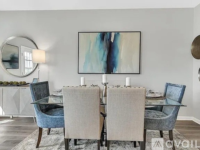 A modern dining room with a glass table and blue chairs.
