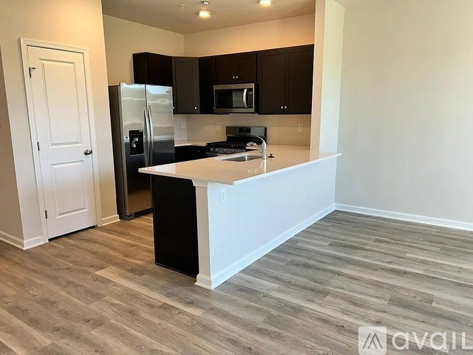A kitchen with a white island and a refrigerator.