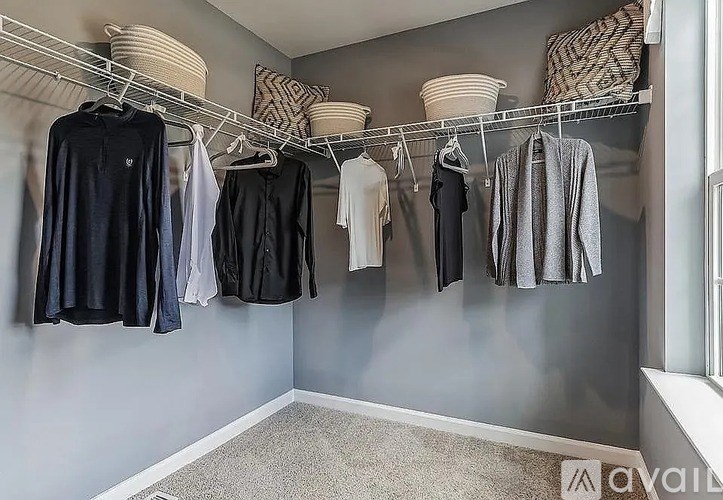 A row of clothes hanging on a rack in a room.