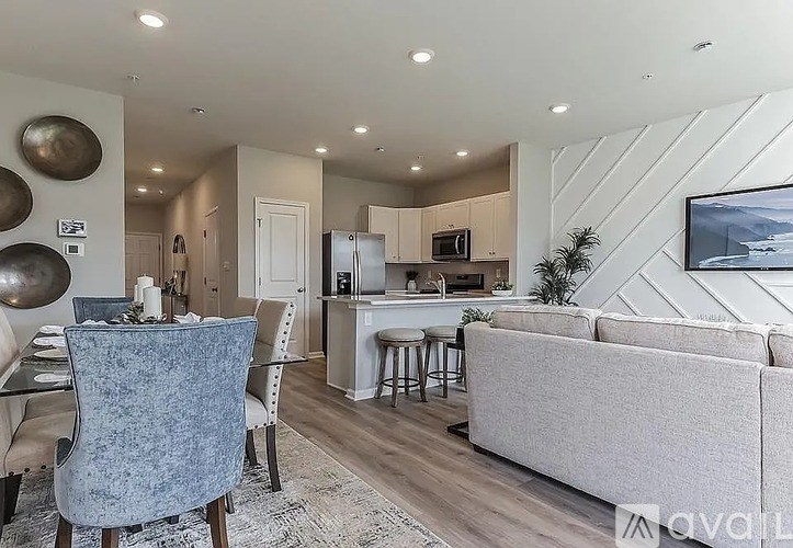 A modern living room with a grey sofa and a dining table set up.