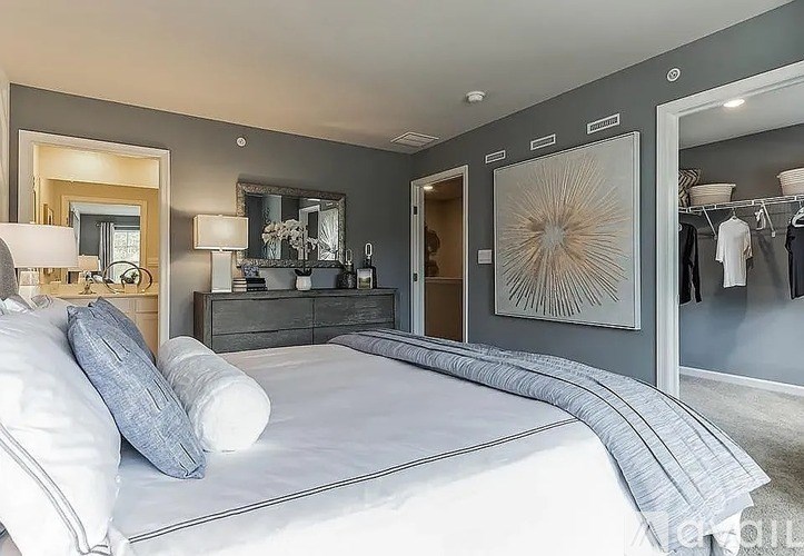 A bedroom with a large bed and a mirror on the wall.