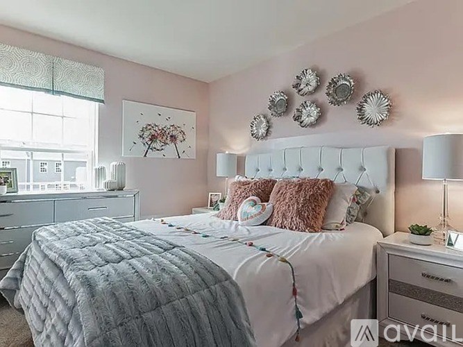 A bedroom with a large bed, a dresser, and a window with blinds.