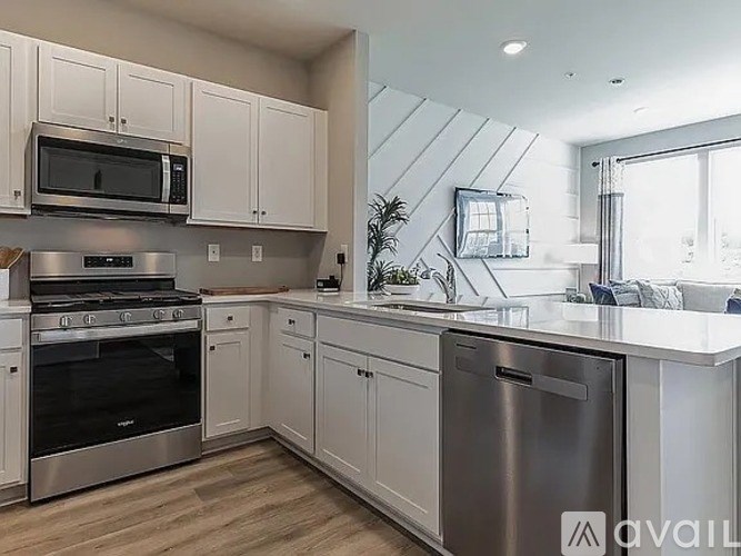 A modern kitchen with stainless steel appliances and white cabinets.