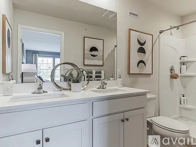 A bathroom with two sinks and a toilet.