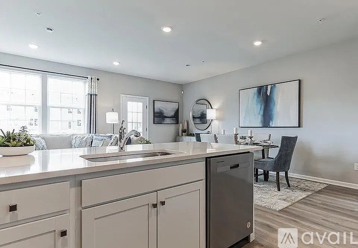 A modern kitchen with a large island and a dining area.
