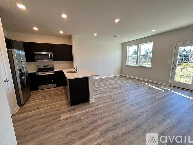 A spacious kitchen with a refrigerator, microwave, and oven.