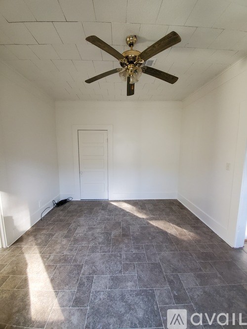 A room with a ceiling fan and tile flooring.