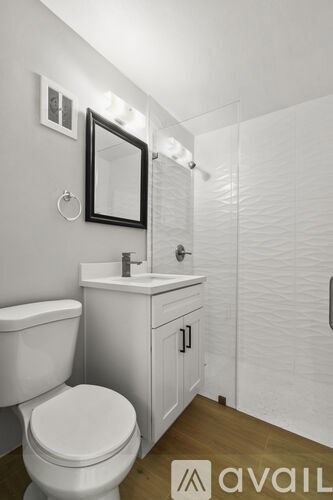 A bathroom with a toilet, sink, and mirror.