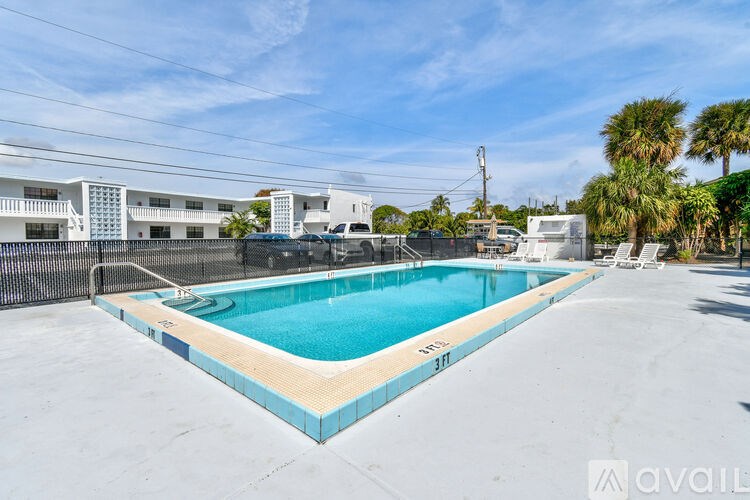 A swimming pool with a blue tiled edge and a white fence surrounding it.