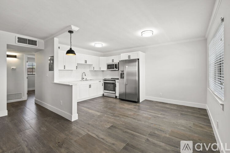 A spacious kitchen with white cabinets and stainless steel appliances.