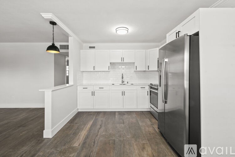 A modern kitchen with a refrigerator, sink, and cabinets.