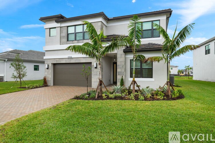 A modern house with a well-maintained lawn and a driveway.