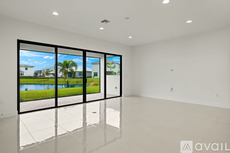 A spacious room with a large window overlooking a pool and a view of the sky.