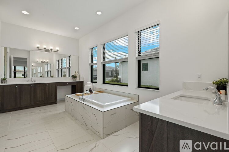 A bathroom with a large tub and a double sink vanity.
